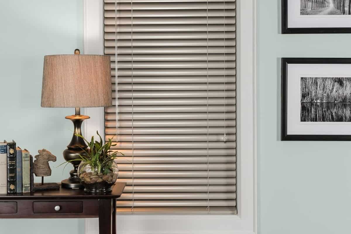 A wall featuring a window covered with Hunter Douglas Modern Precious Metals® Aluminum Blinds